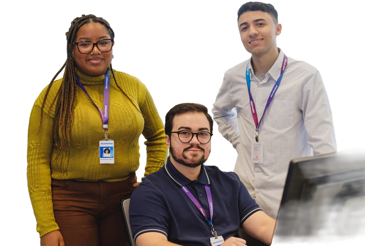 Três estagiários da AkzoNobel sorrindo no escritório, com crachás da empresa