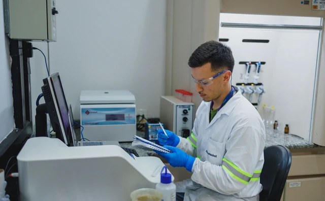 Pesquisador de jaleco trabalhando com equipamentos no laboratório
